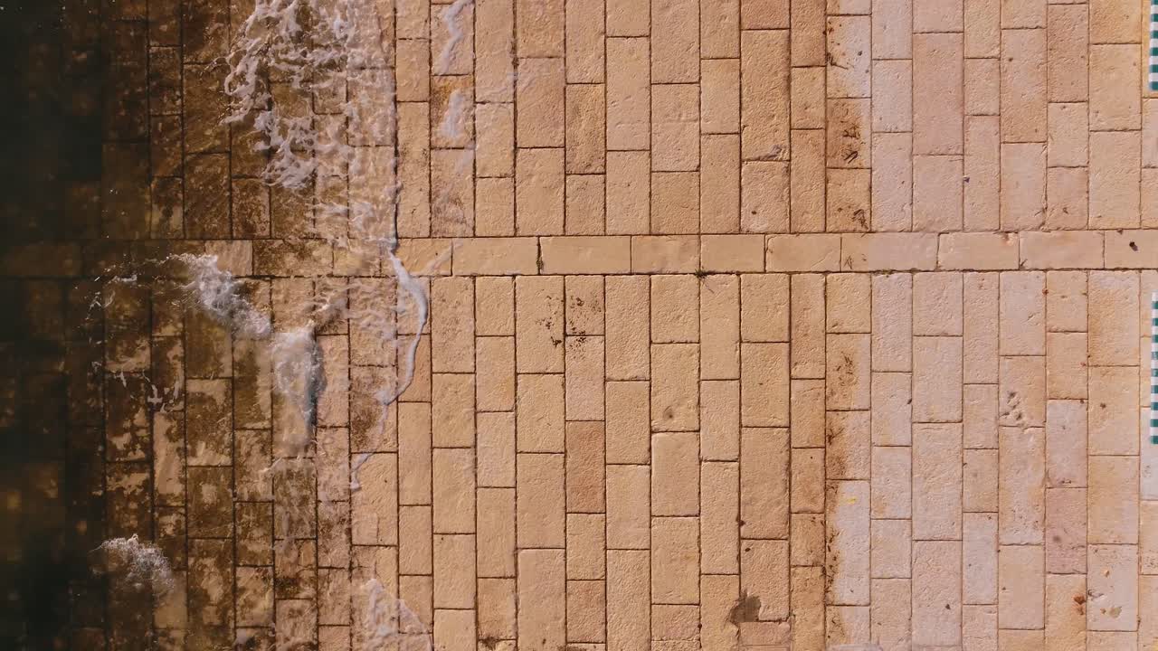 돌에 부드럽게 튀는 작은 파도의 오버 헤드 샷, parque das nações, lisboa, portugal