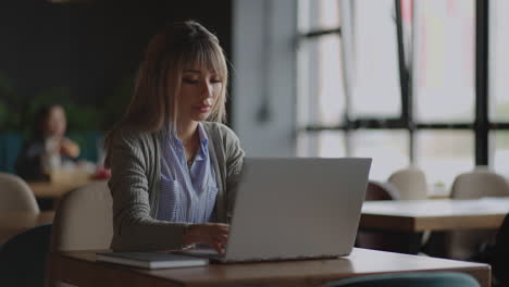 trabajo en línea en la computadora portátil de una mujer asiática en el campus