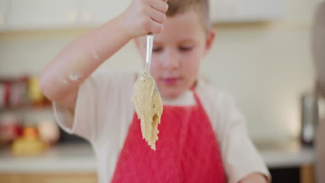 boy mixing dough in a bowl