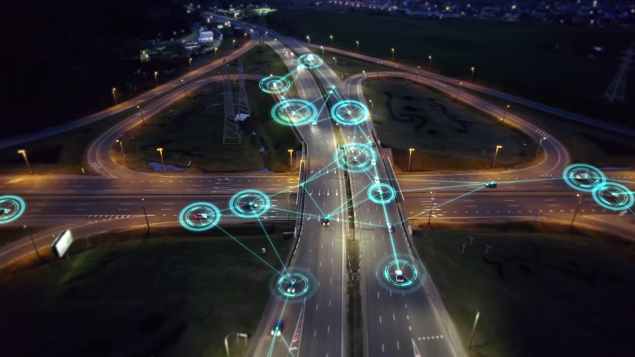 Vista aerea di veicoli autonomi connessi su svincolo autostradale di notte