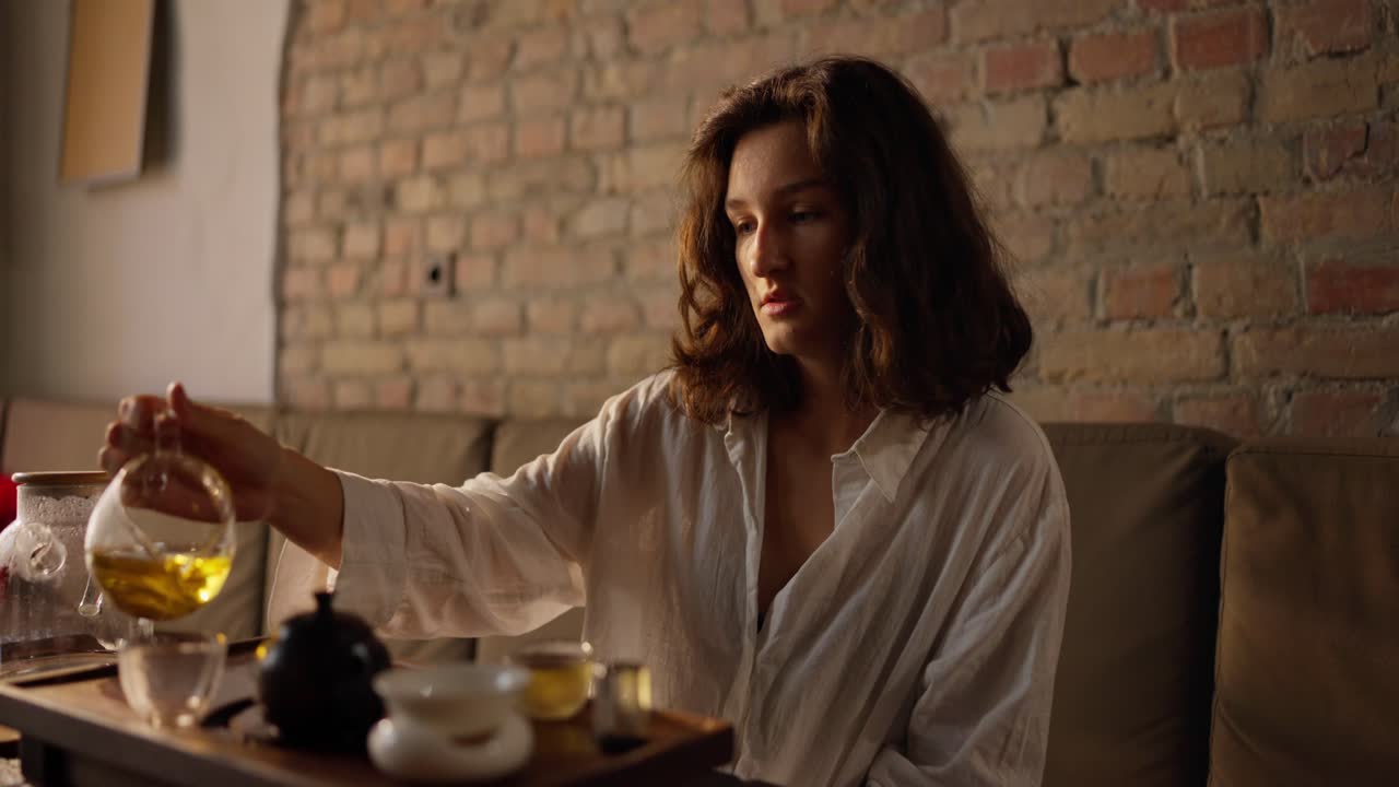 женщина наливает чай во время чайной церемонии