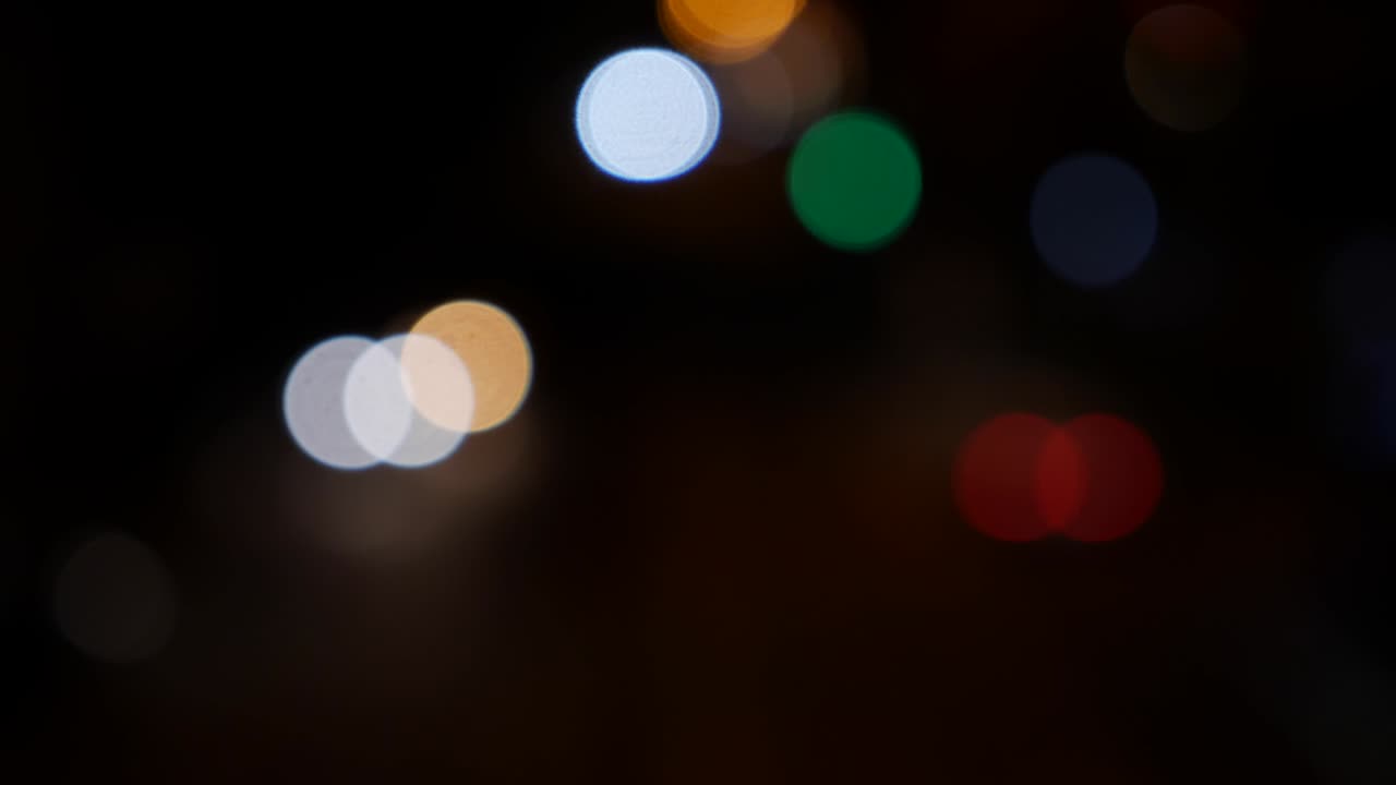 hermoso bokeh brillante en el fondo oscuro borroso por la noche. el redondo bokeh colorido brilla de las luces de los coches en la calle de la ciudad. fuera de foco con borroso. luces de la ciudad sin enfoque. bokeh de tráfico. concepto abstracto
