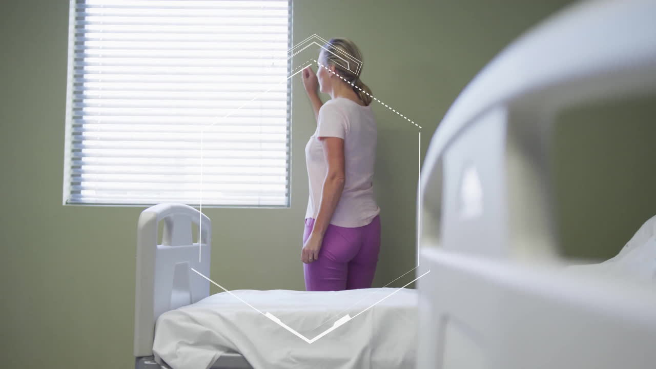 Standing by hospital bed, woman looking out window with animation overlay