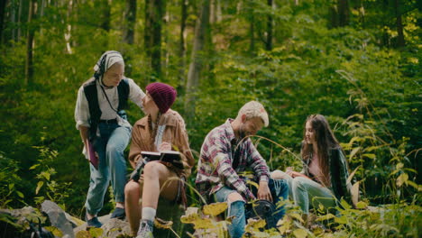 friends enjoying together sitting on rocks in forest