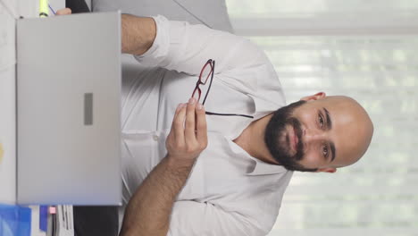 Vertical-video-of-Home-office-worker-man-smiling-at-camera.