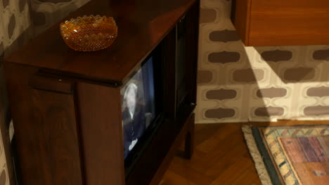 a vintage wooden television in a retro living room with an ashtray