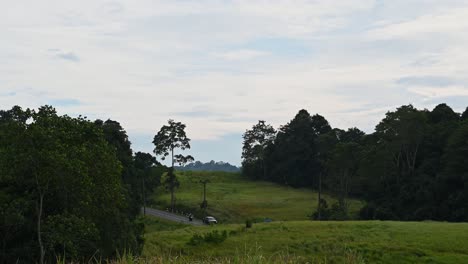 Aléjese-De-Este-Hermoso-Paisaje-En-El-Parque-Nacional-De-Khao-Yai-En-Tailandia,-Donde-Se-Ven-Autos-Moviéndose-Hacia-La-Derecha-Durante-Una-Tarde-Nublada