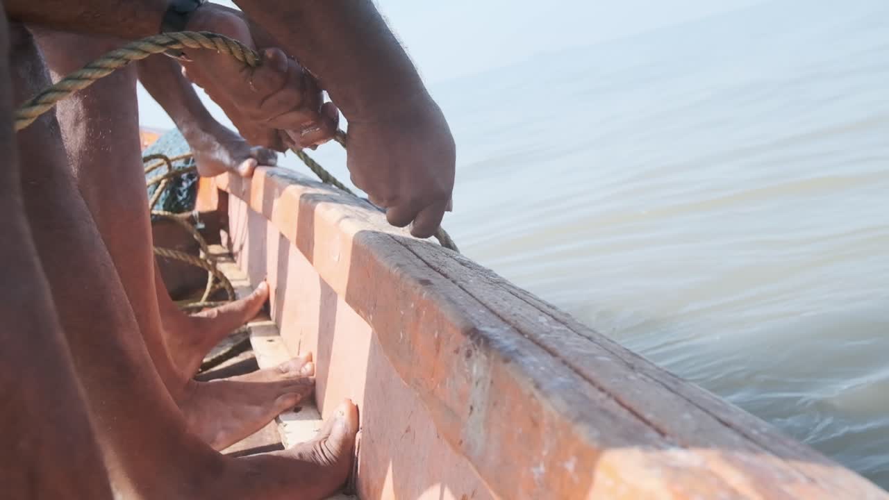 pescadores indios tirando de la red de pesca azul llena de peces y camarones del mar a cámara lenta