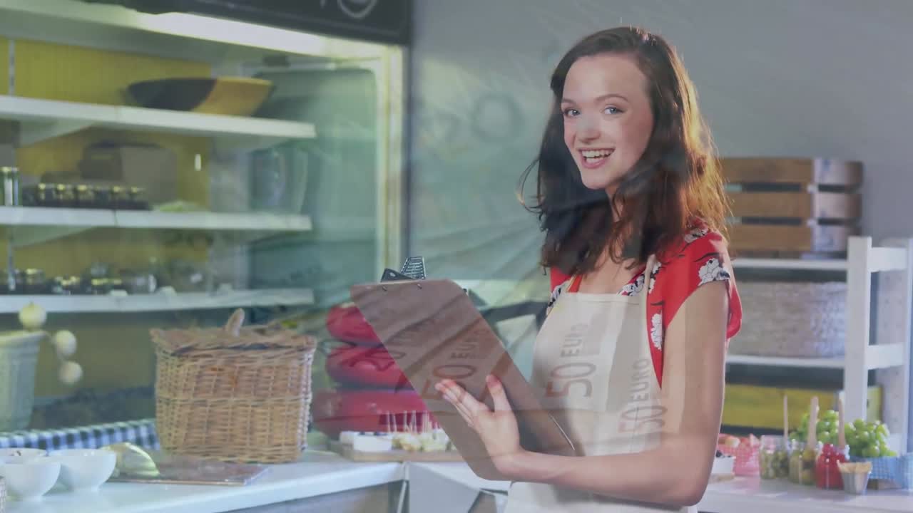 animación de gráficos financieros sobre una feliz vendedora caucásica en una tienda de comestibles
