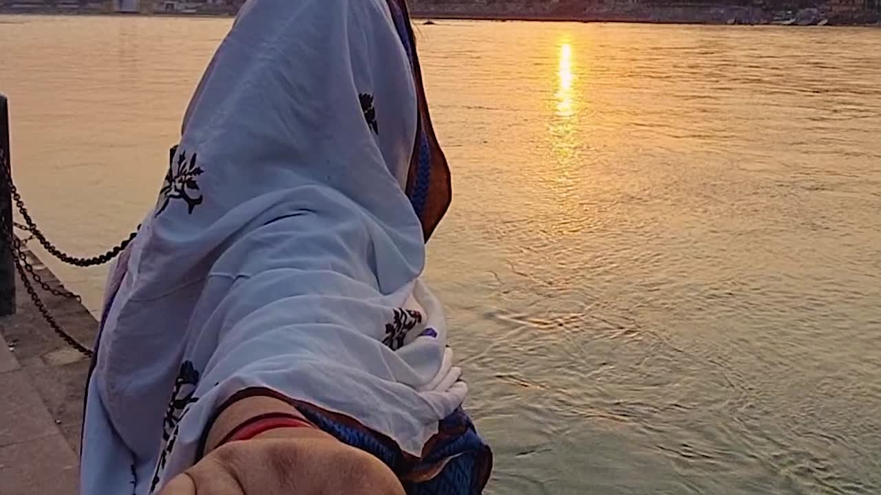 pareja abrazándose en la orilla del río al atardecer desde un ángulo plano video tomado en rishikesh uttrakhand india el 15 de marzo de 2022