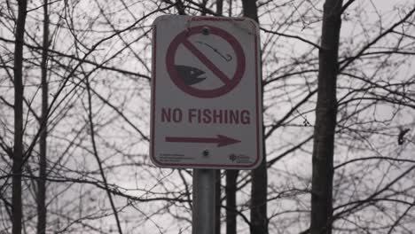 no fishing sign posted at a public park image of hook and fish black and white city governement sign