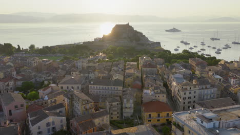 The Old Fortress in old town of Corfu during sunrise with flock of swallows flying around, Drone shot