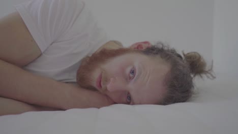 sad man lying on a bed