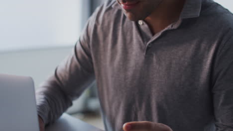 Businessman-Working-Late-On-Laptop-At-Desk-In-Office-Making-Online-Payment-With-Credit-Card