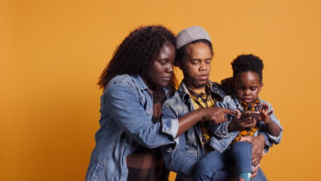 Cheerful-african-american-family-taking-pictures-against-yellow-background