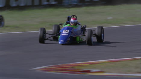 dos autos de carreras corren alrededor de una pista