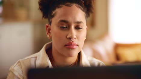een jonge vrouw die thuis aan haar laptop werkt