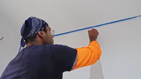 man painting wall with paintbrush - close up