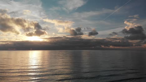 majestic aerial sunset over ocean with wonderful lights reflections over satin water with breathtaking multicolored pastel sky