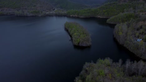 aerial ascend over island in a lake during a stormy winter day