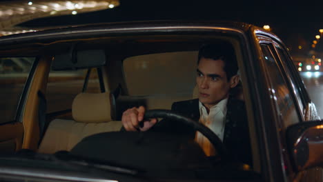 car driver sitting automobile waiting at night close up. man holding auto helm