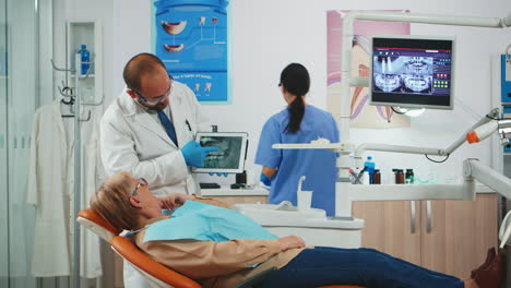 dentist showing on tablet teeth x-ray