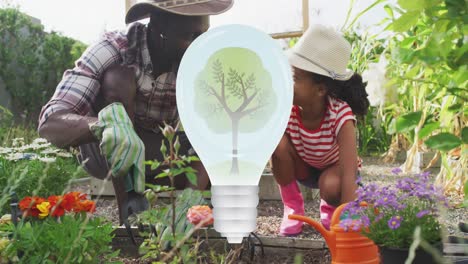 Animation-of-light-bulb-with-tree-over-african-american-father-and-daughter-in-garden