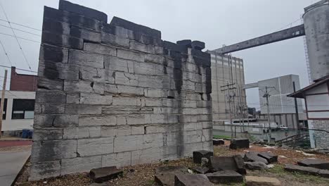 Benjamin-Godfrey-Historical-Site-with-Ruins-of-the-First-State-Prison-Wall-and-Ardent-Flour-Mill-in-the-Background,-Alton,-Illinois,-USA