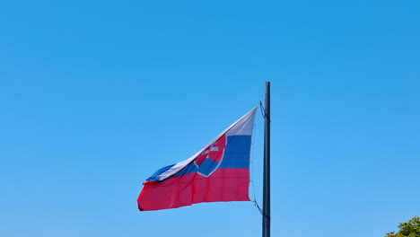 Flag of Slovakia waving in the wind. Slovak flag at the backdrop of blue clear sky