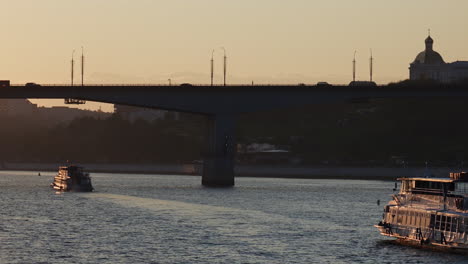 sunset river scene with bridge and historic buildings