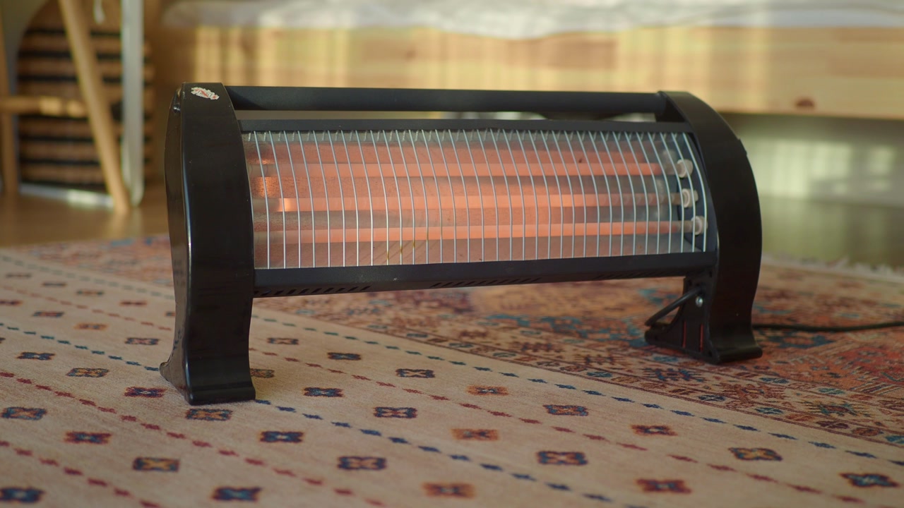 Electric Infrared Heater with Glowing Elements on a Rug