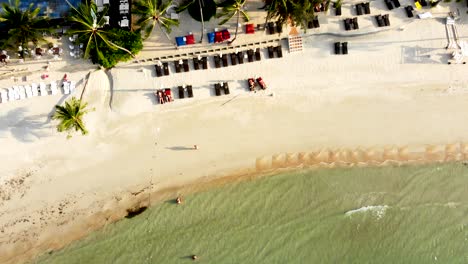 Overhead-drone-shot-moving-from-top-to-bottom,-revealing-the-beachfront-of-Thongson-Bay-and-the-resorts-by-the-sea,-located-in-Koh-Samui-island,-in-Surat-Thani-province,-in-Thailand