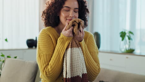 woman smelling a cozy scarf at home