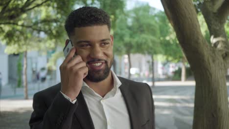 Un-Joven-Exitoso-Hablando-Por-Teléfono-Al-Aire-Libre.