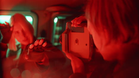 man filming girlfriend dancing in car with vintage camcorder