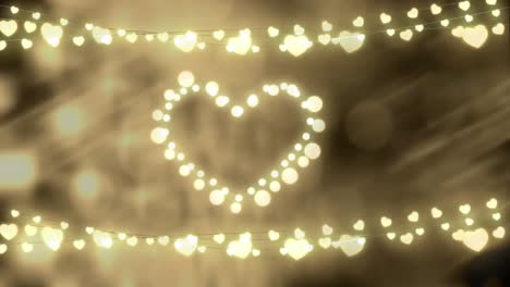 glowing heart and strings of fairy lights on defocused background