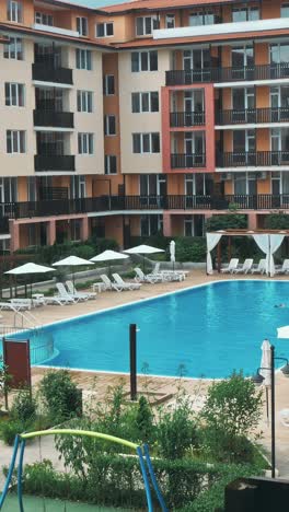personas sentadas a la orilla de la piscina de un resort durante las vacaciones de verano