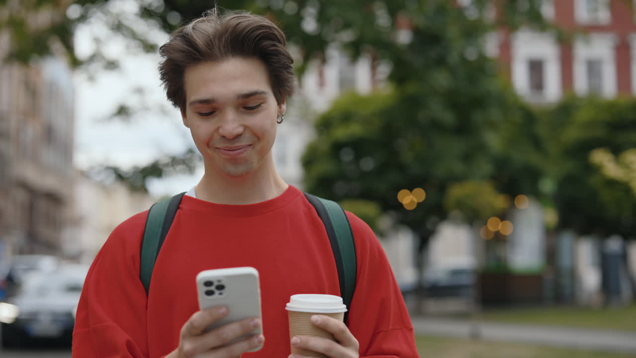 Man with phone and coffee on the street