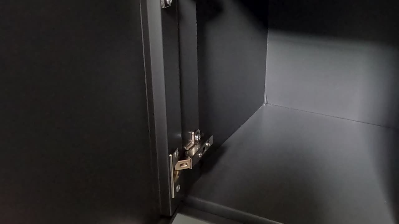A person opens and examines the interior of a digital locker, focusing on the keypad and handle.