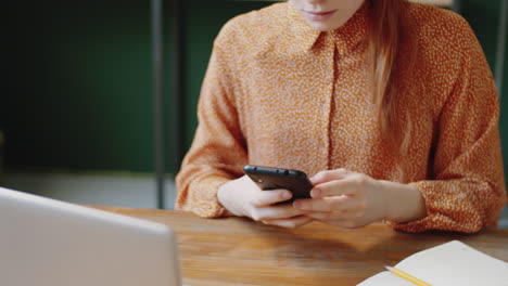 mujer usando un teléfono inteligente en un escritorio