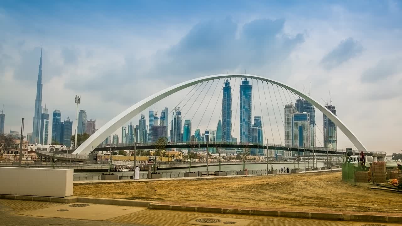 Time-lapse del Canale d'Acqua di Dubai con il movimento delle nuvole e il Burj Khalifa sullo sfondo, con il movimento delle persone nella zona