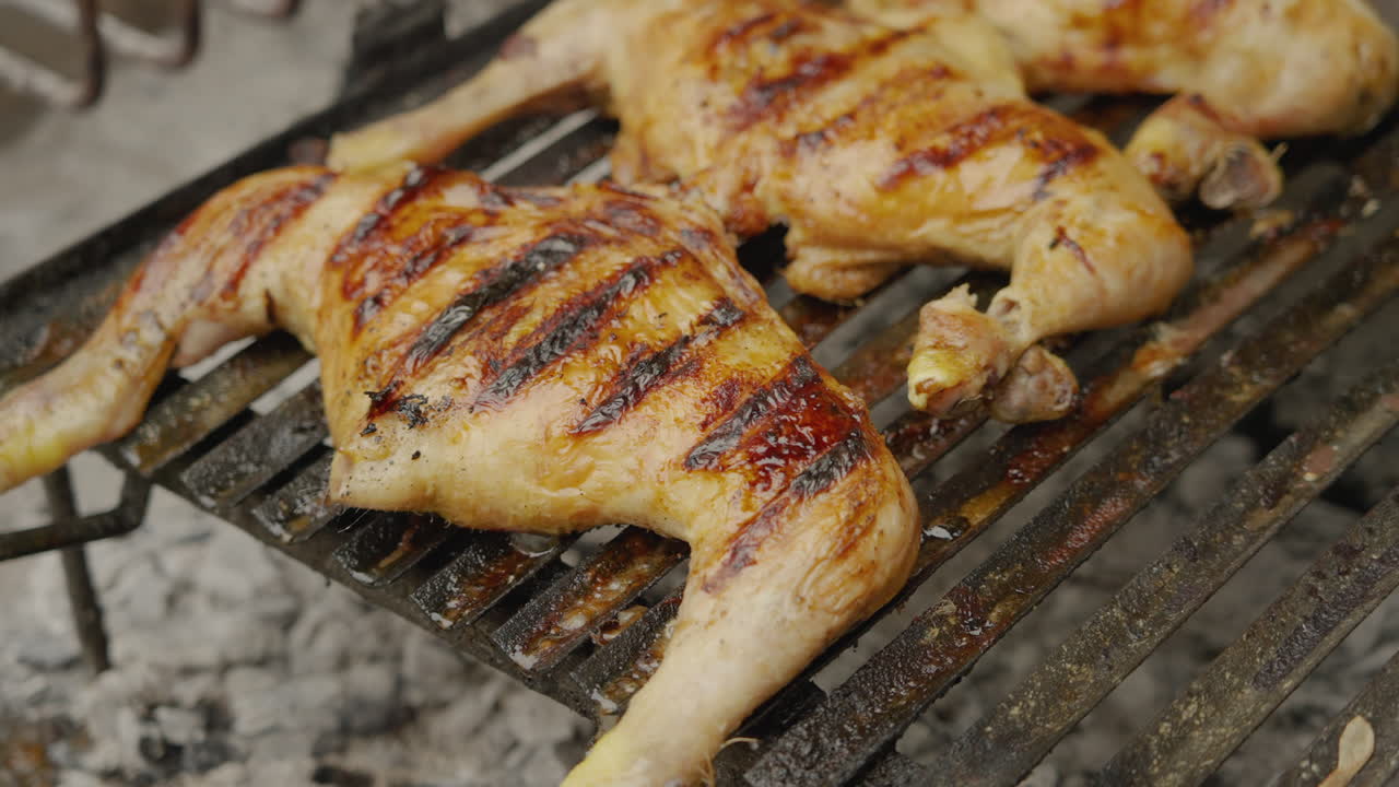 Metà di pollo che grigliano su un barbecue.