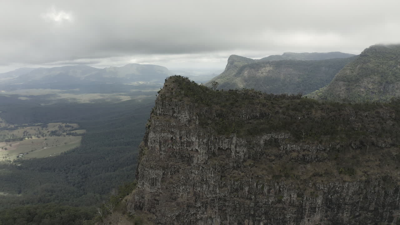 el disparo de un dron de 4k se mueve lentamente hacia un gran acantilado de montaña en el parque nacional border ranges, nueva gales del sur, australia