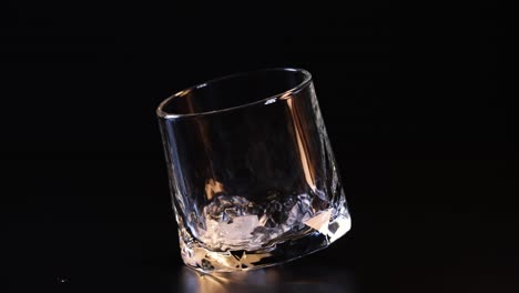 ice cube dropped, glass tilts and stabilizes