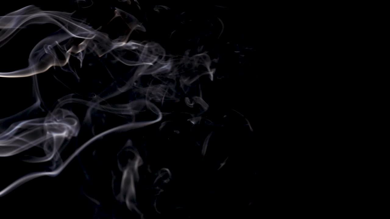 White soft smoke texture isolated in dark background. White mysterious smoke on black background.