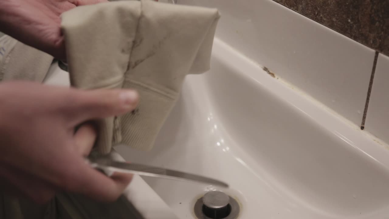 A Stained Cloth Meticulously Cleaned By A Knife