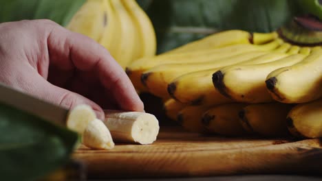 hands men cut the banana into round slices.