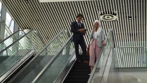 young business people on an escalator in a modern building