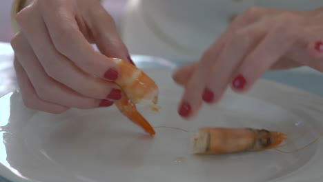 woman peels a prawn at a celebration