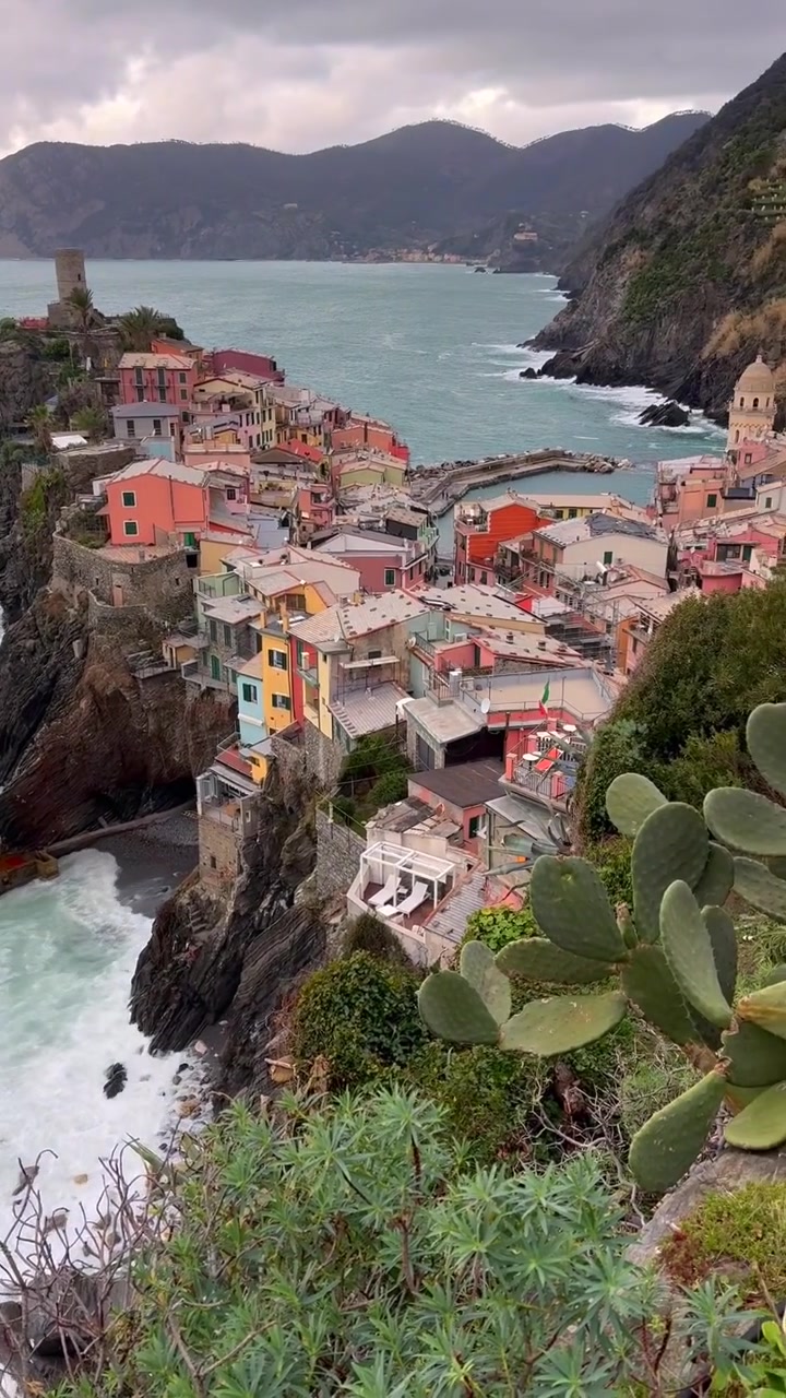 Vue pour les réseaux sociaux de bâtiments aux couleurs pastel le long de falaises rocheuses au-dessus de l'eau turquoise méditerranéenne, un paysage côtier spectaculaire capturant la beauté pittoresque de Vernazza, Cinque Terre, Italie.